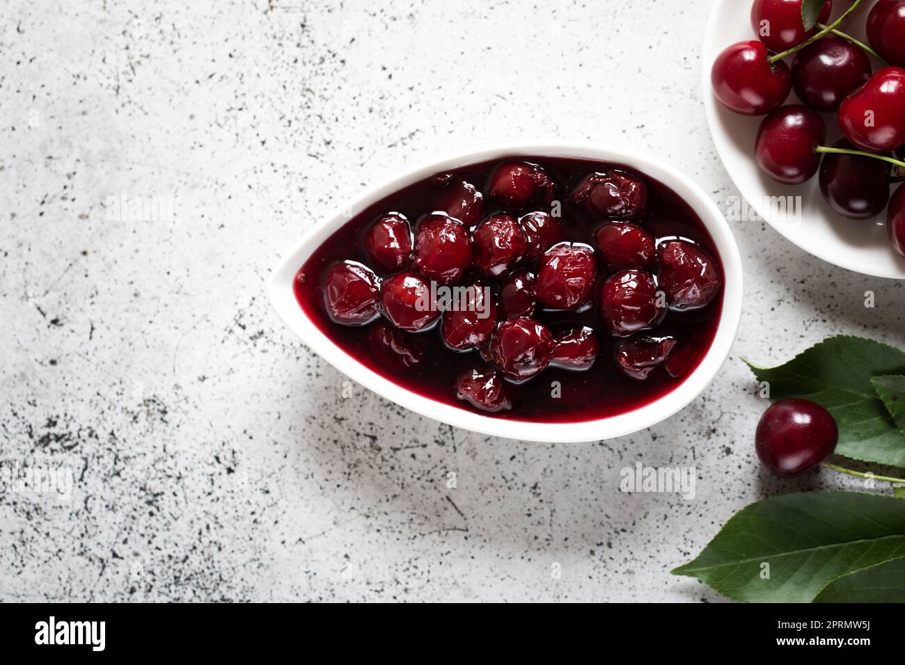 confettura di ciliegie e ciliegie fresche in una ciotola, conserve fatte in casa Foto Stock