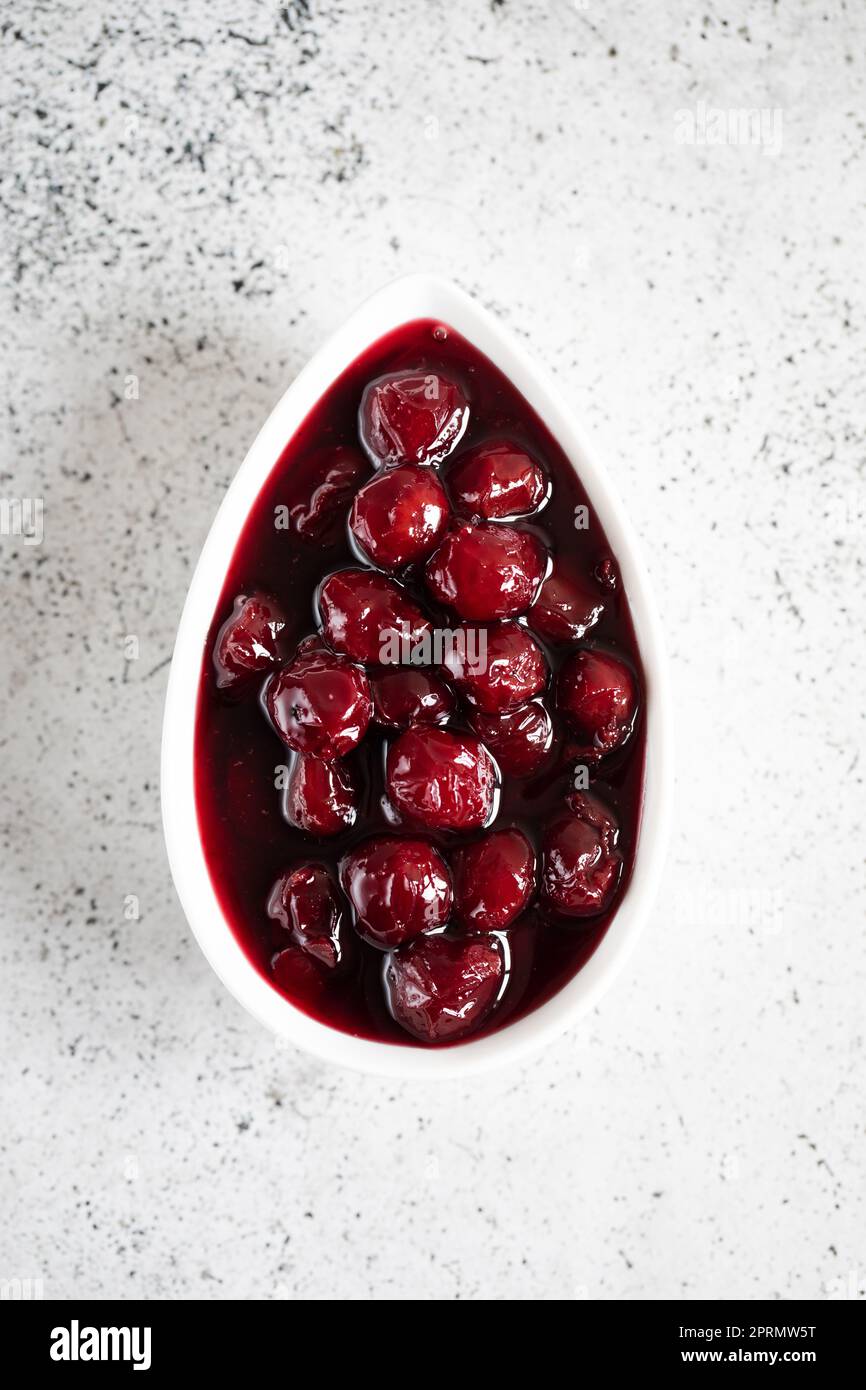 confettura di ciliegie e ciliegie fresche in una ciotola, conserve fatte in casa Foto Stock