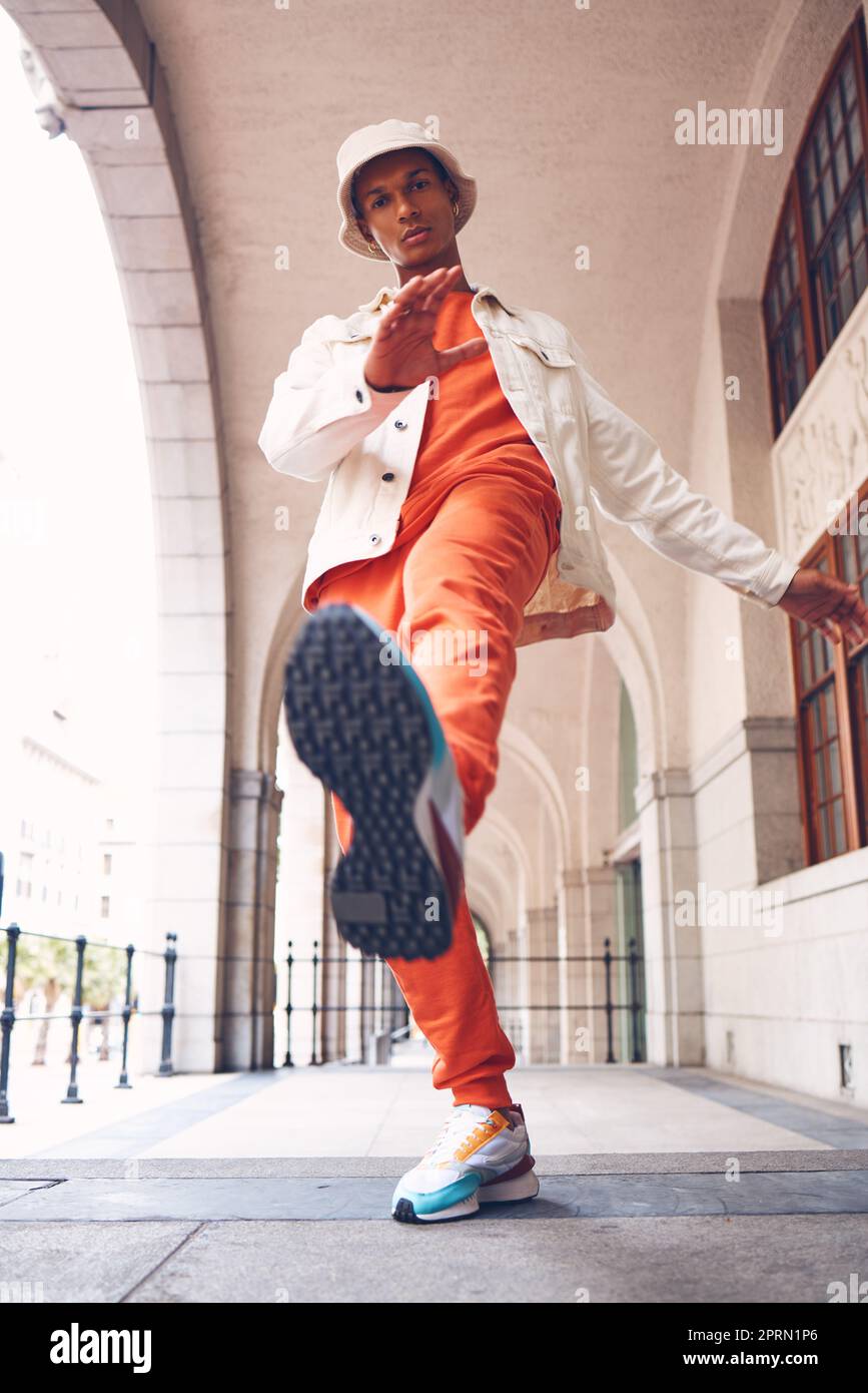 Moda modella e gen z man dalla Spagna con abiti al neon di tendenza e di lusso. Marchio di abbigliamento e calci per le gambe di una persona spagnola hipster con scarpe