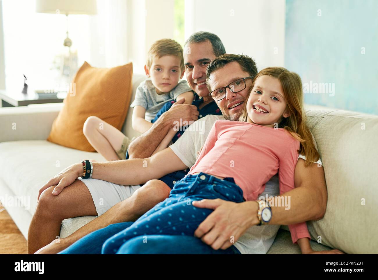 La famiglia è l'unica cosa che conta. Ritratto corto di una famiglia affettuosa di quattro sul divano di casa Foto Stock