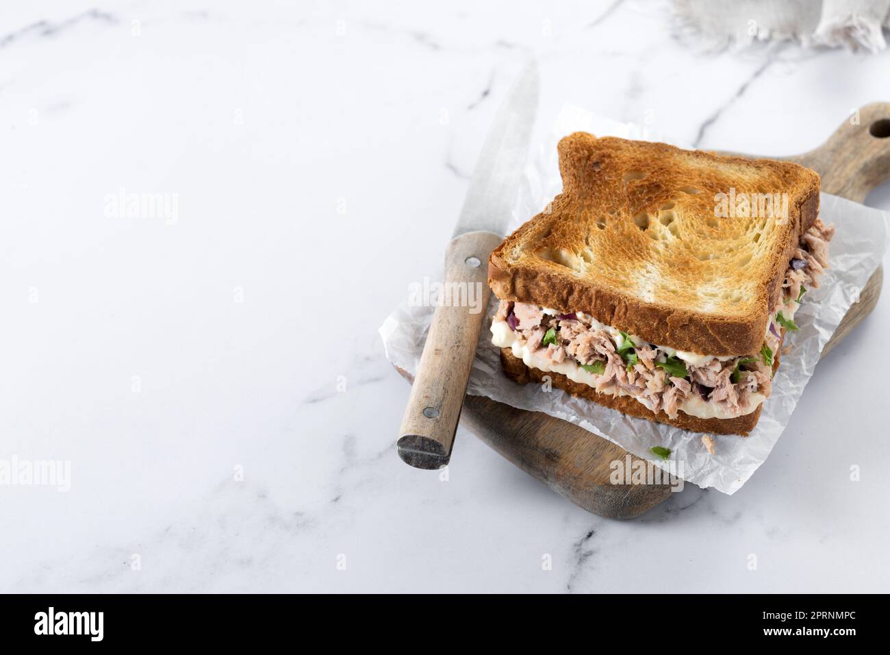 Panino di tonno con mayo e verdure su marmo bianco Foto Stock