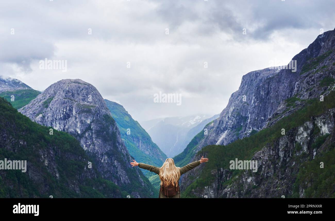 Avventura di viaggio donna celebra le braccia alzate in vista della maestosa valle glaciale in esplorazione scoprire la splendida terra Foto Stock