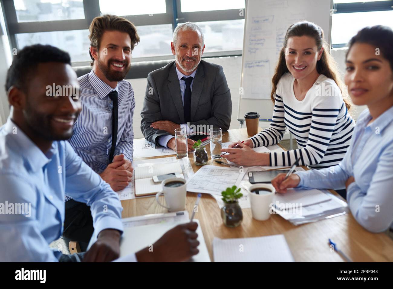 Pianificare prima, agire secondo. Un gruppo di colleghi seduti attorno a un tavolo nella sala riunioni. Foto Stock