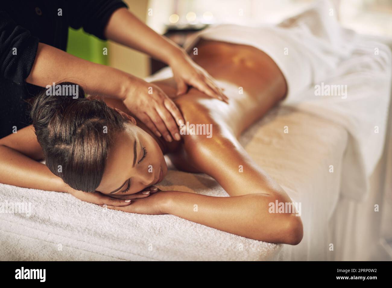 Serenità del centro benessere. Scatto ad angolo alto di una giovane donna che ottiene un massaggio alla stazione termale. Foto Stock