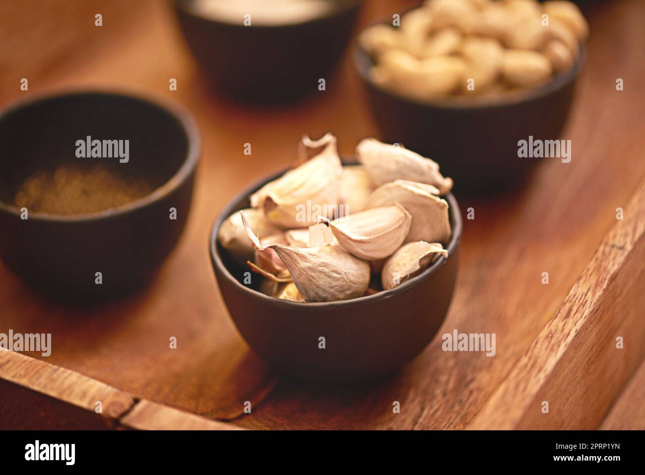 Garlicgood per voi, buono per il vostro cibo. Ciotole di spicchi freschi di aglio su un tavolo. Foto Stock