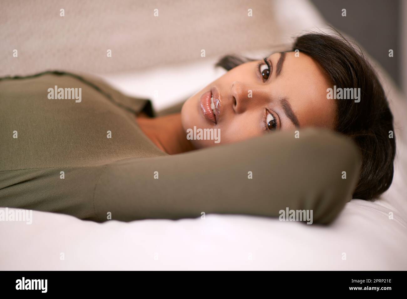Oggi è una giornata pigra, solo relax. Ritratto di una giovane donna sdraiata sul suo letto. Foto Stock