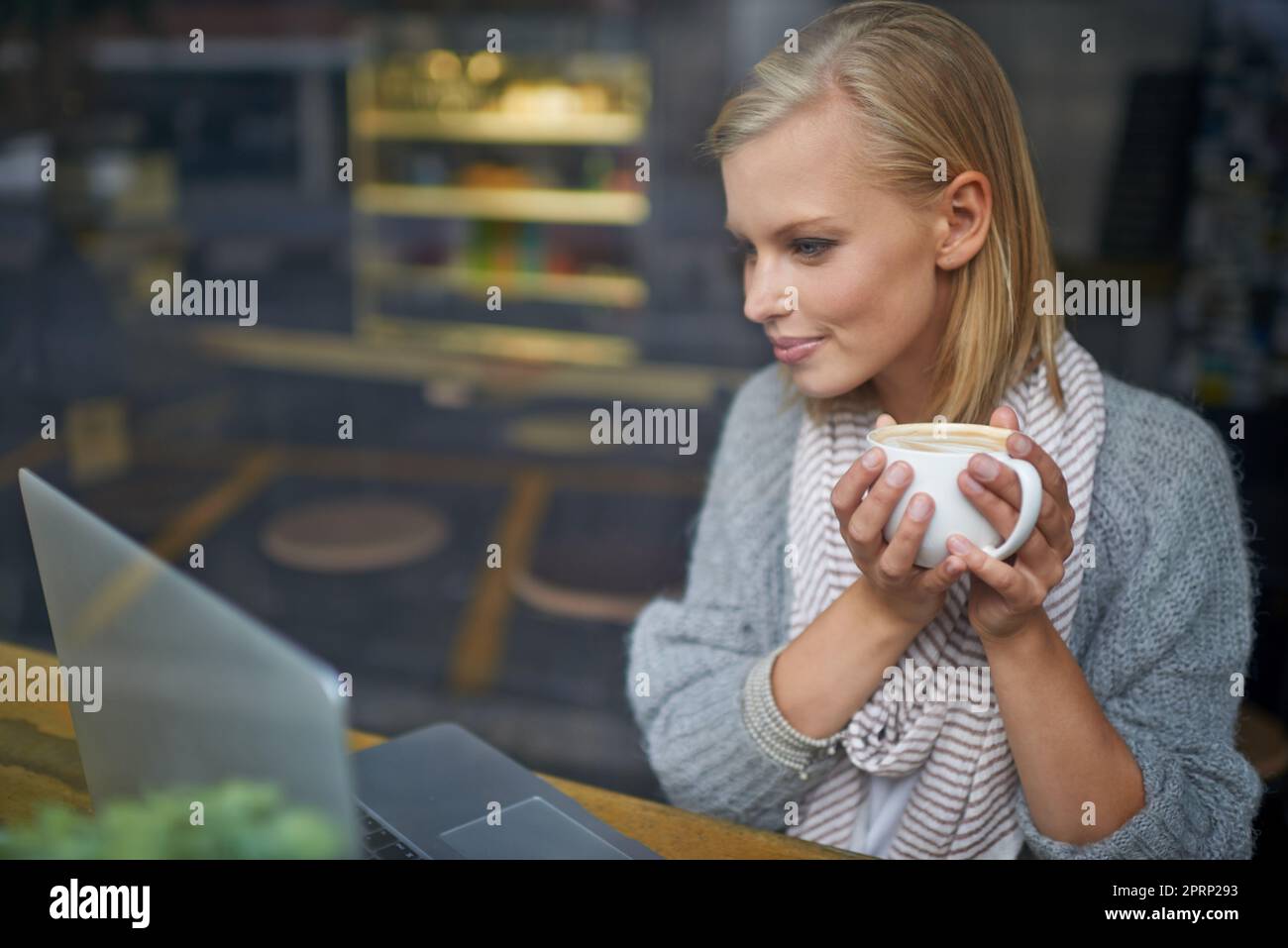 Abbiamo tutti bisogno di un posto per essere soli. Una giovane donna seduta in una caffetteria. Foto Stock