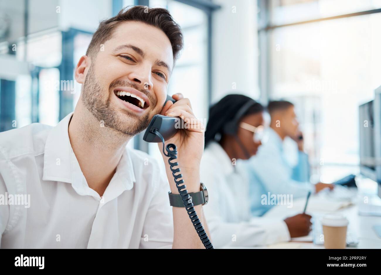 Un lavoratore di telemarketing felice chiama in ufficio, una società pubblicitaria aziendale e un agente di call center ridendo. Collega dell'help desk, operatore telefonico aziendale e team di assistenza clienti che lavorano Foto Stock