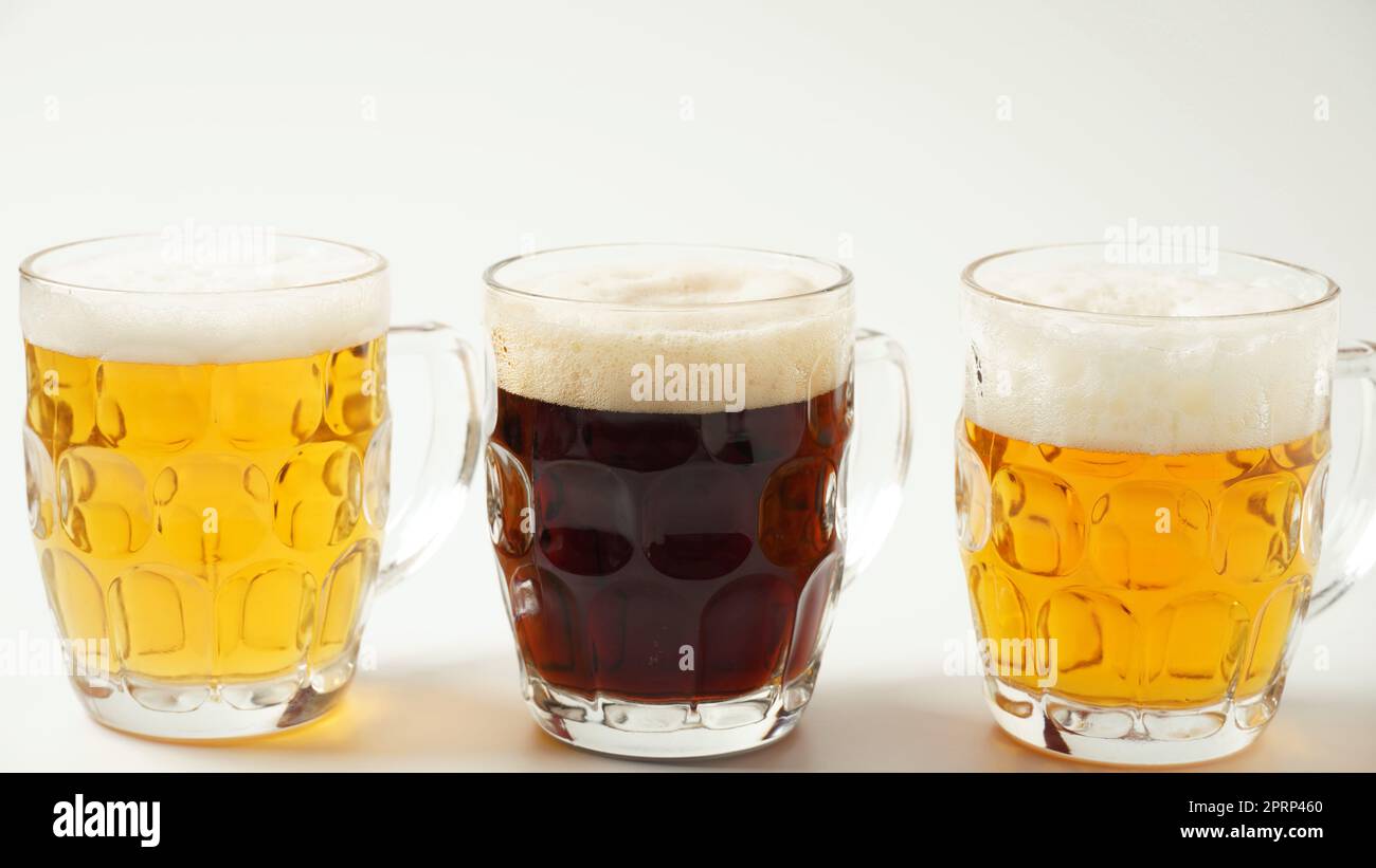 Tre tazze di birra di sapore diverso - chiaro, scuro e rosso Foto Stock