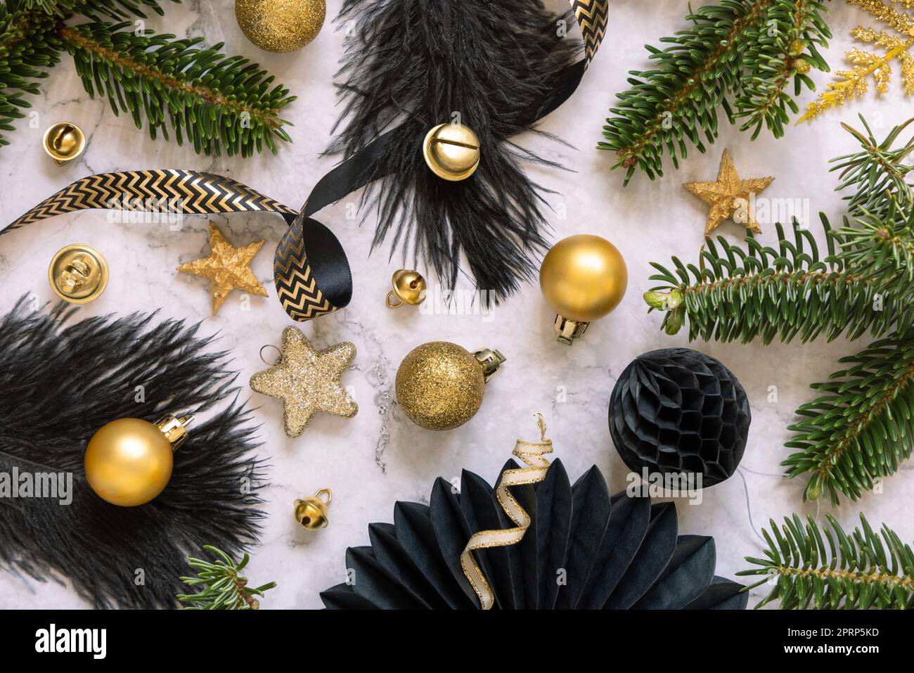 Ornamenti natalizi neri e dorati, bauble e rami di abete con vista dall'alto in marmo Foto Stock