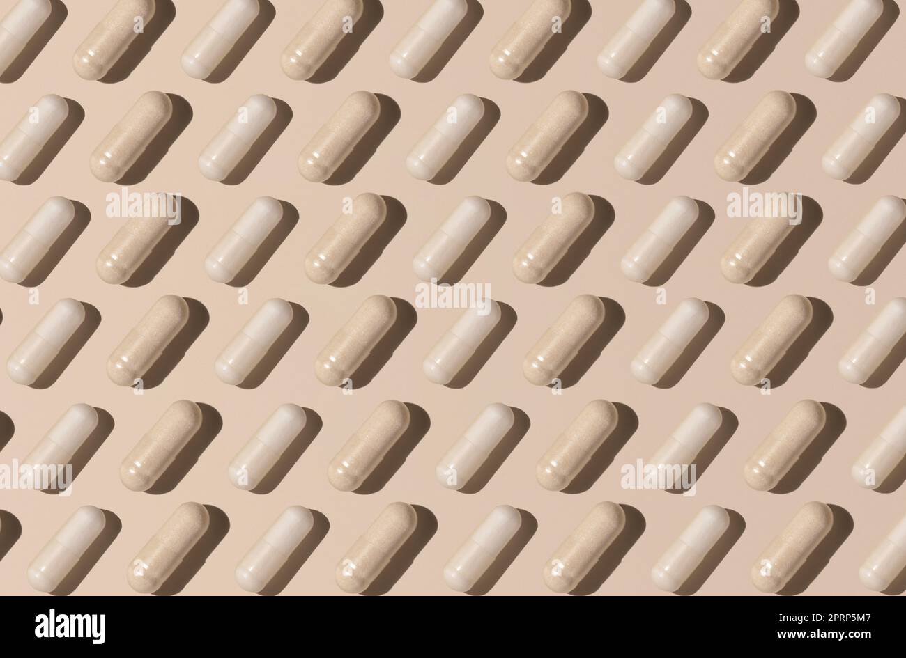 Modello creativo con capsule sulla vista dall'alto beige chiaro, ombre rigide. Assunzione di integratori Foto Stock