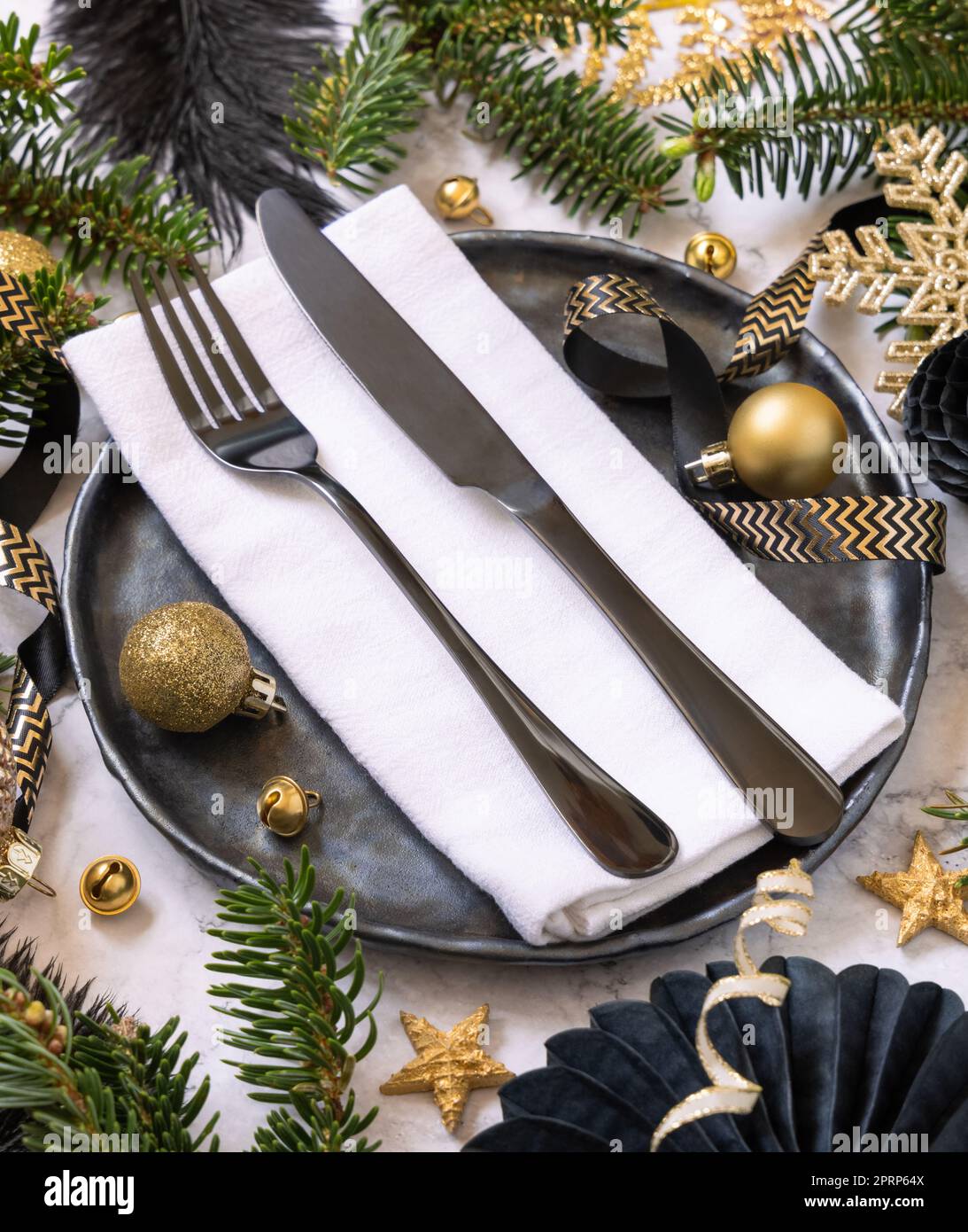 Tavolo di Natale nero e dorato con decorazioni e rami di abete da vicino Foto Stock