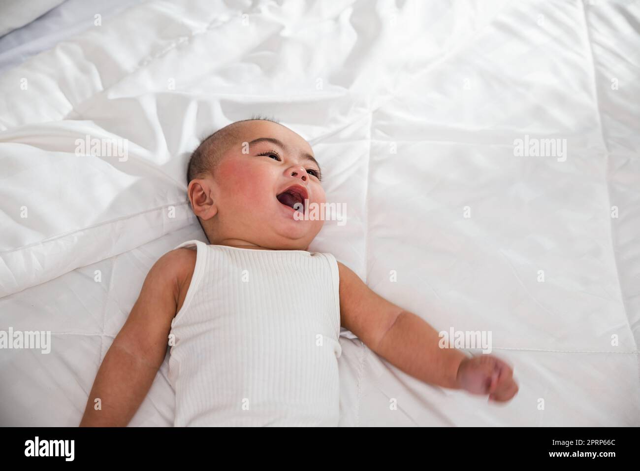 Asiatico carino bambino piccolo a letto sotto morbida coperta Foto Stock