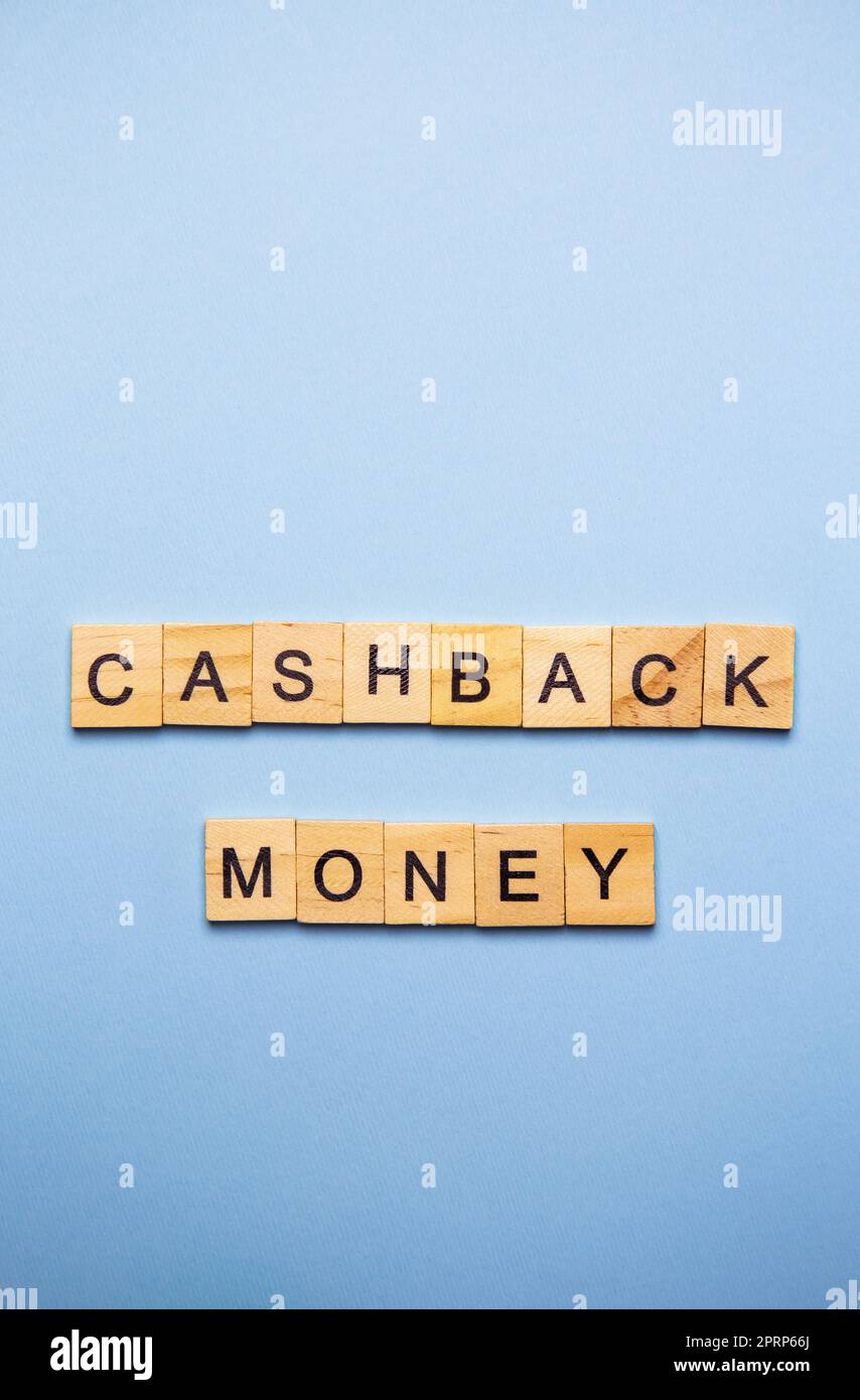 Concetto finanziario. Su una superficie blu, cubi di legno con l'iscrizione denaro di cashback. Foto verticale. Foto Stock