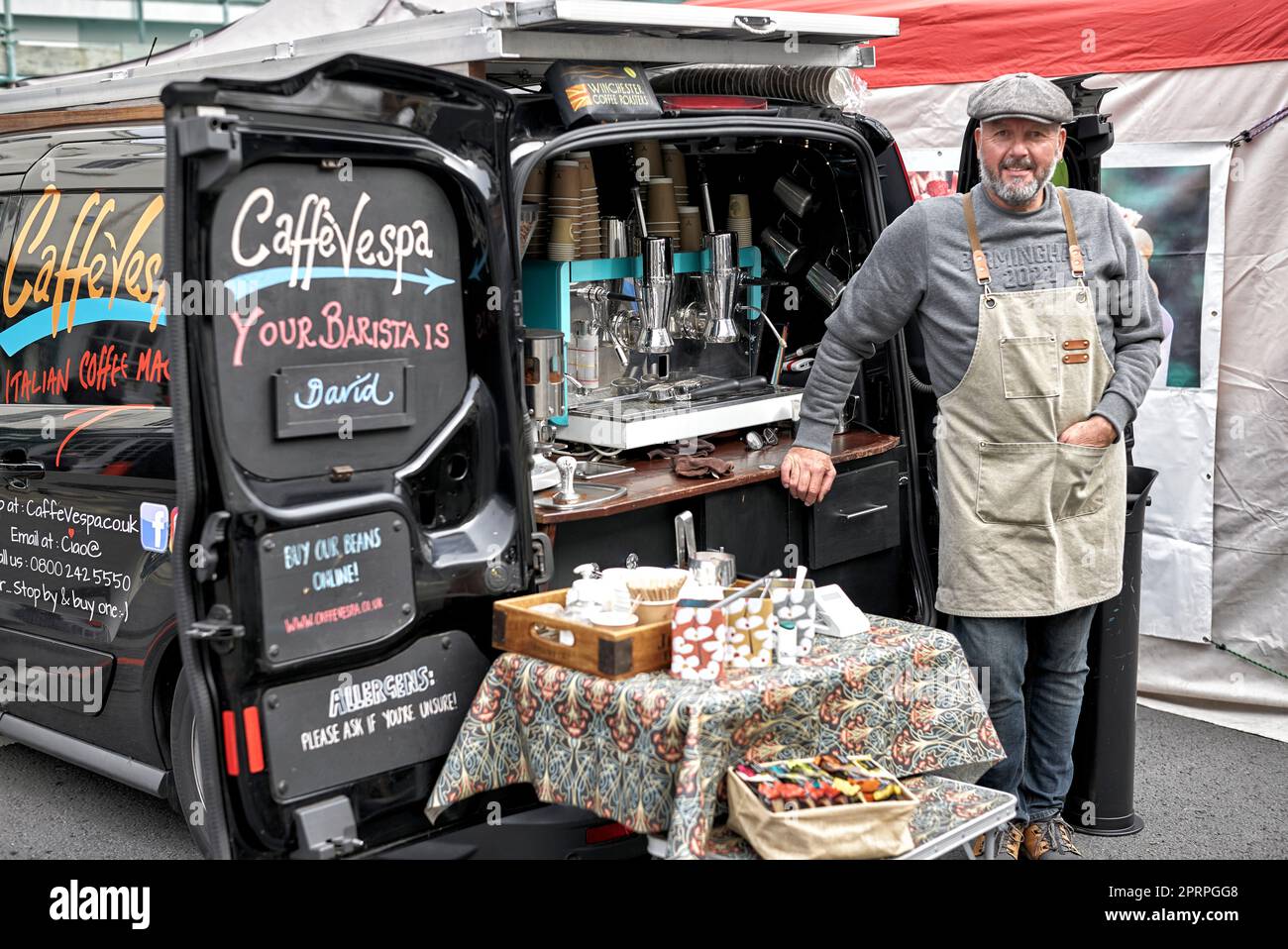 Veicolo mobile per il caffè con proprietario barista che serve bevande al caffè all'aperto. Inghilterra Regno Unito Foto Stock