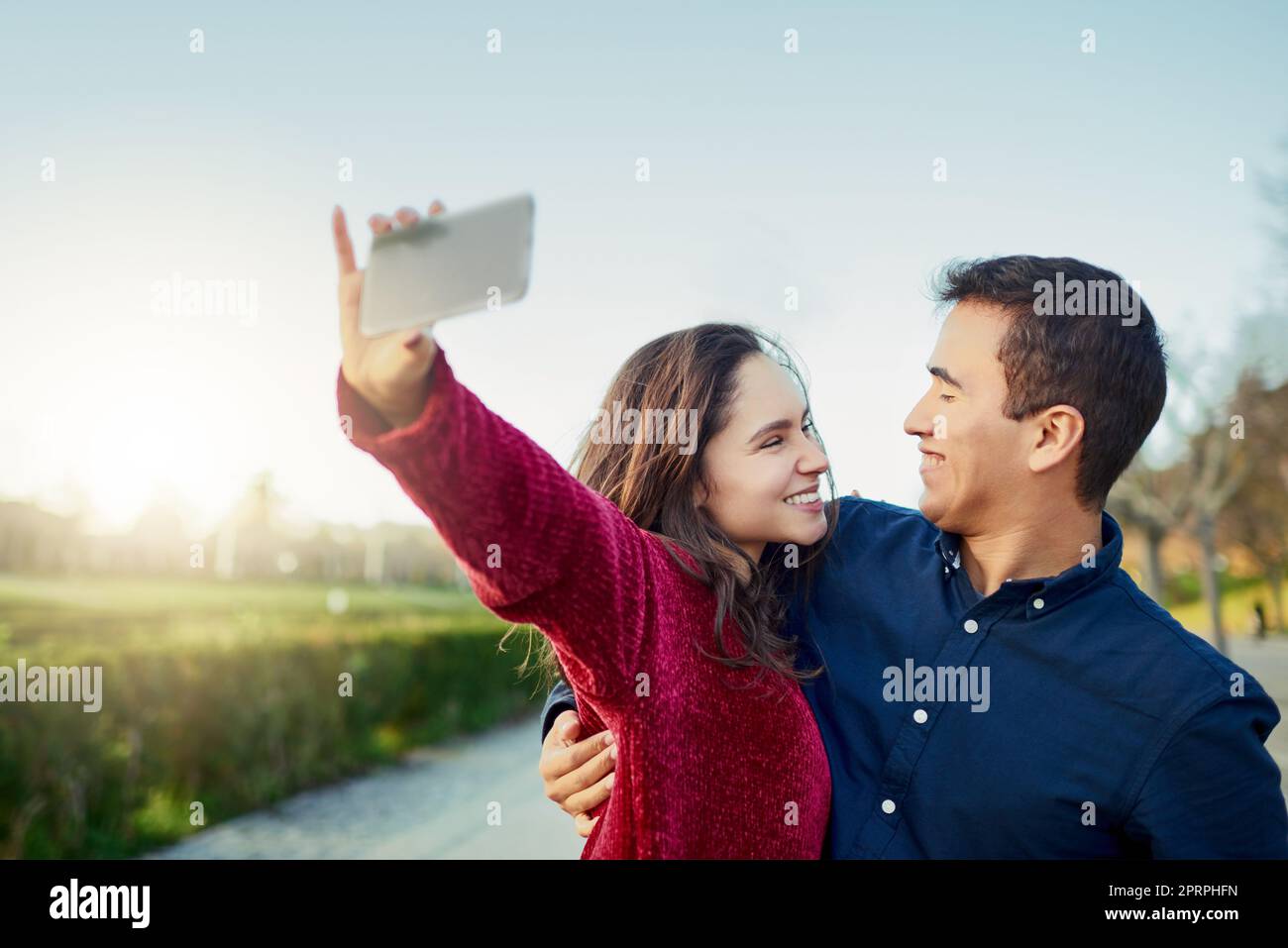 Ricordi ovunque ti trovi. una giovane coppia felice che prende un selfie all'aperto Foto Stock