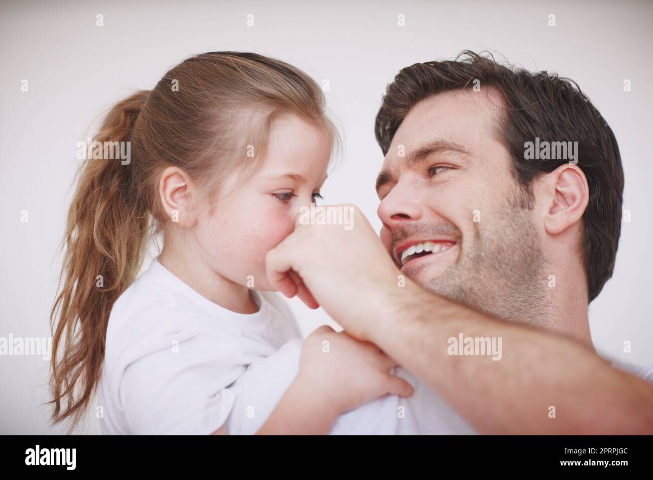 Divertimento e solletico con papà. Un padre e la sua giovane figlia sono affettuosi e trascorrono del tempo di qualità insieme. Foto Stock