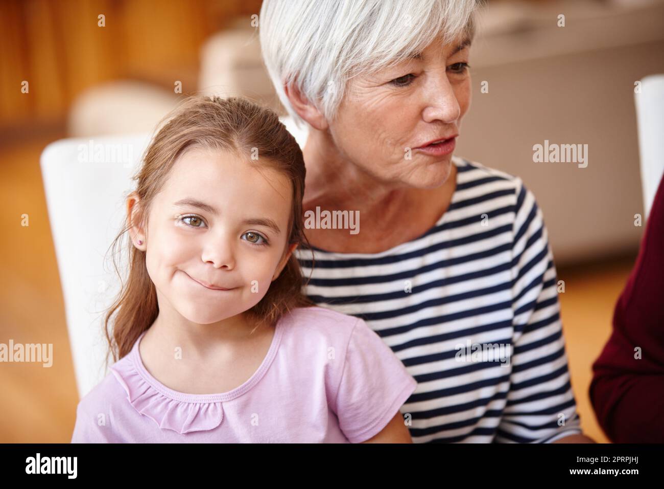 Cibo e famiglia. Ritratto di una bambina seduta sul grembo delle nonne. Foto Stock