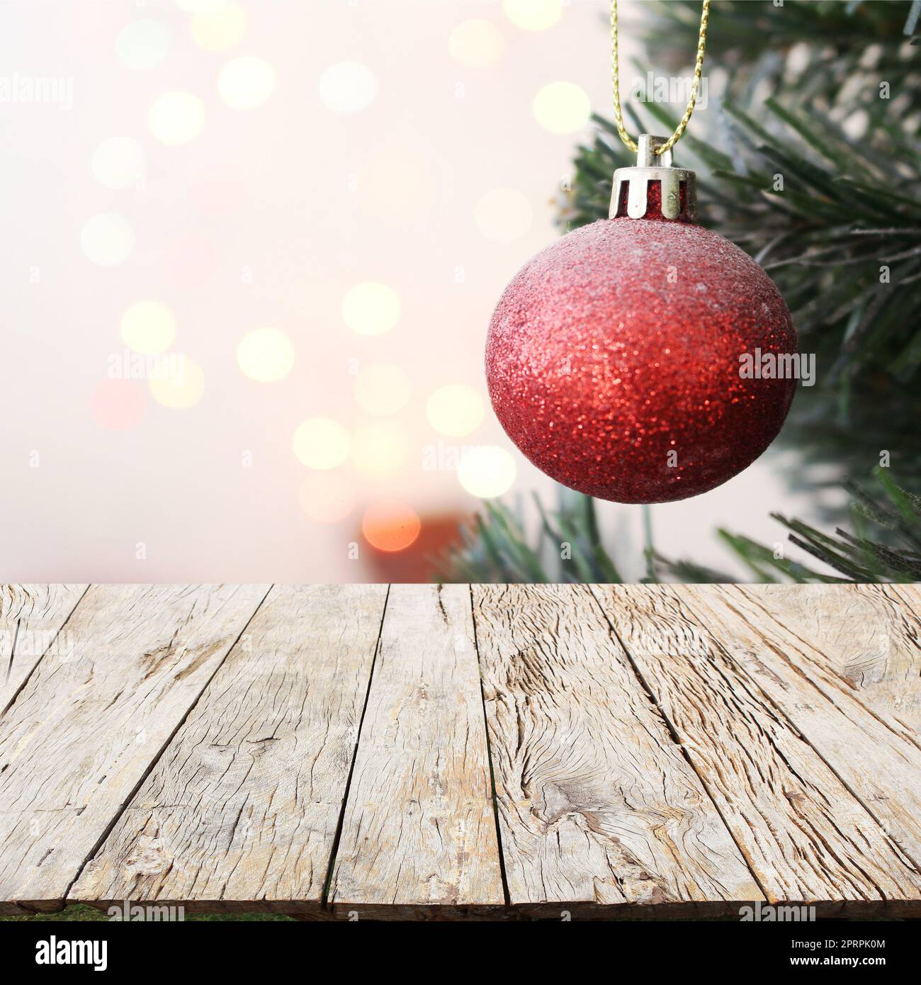 albero di natale con decorazioni palla regalo con sfondo bokeh chiaro su pavimento in legno Foto Stock