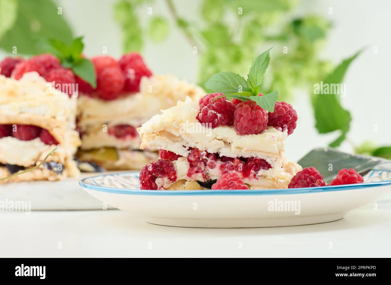 Torta di meringa rotonda con lamponi freschi su sfondo bianco, Pavlova dessert Foto Stock