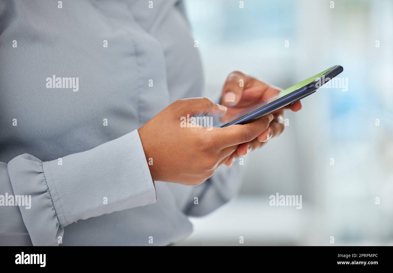 Telefono, mani e comunicazione con una donna d'affari in rete con la tecnologia wifi nel suo ufficio. Primo piano di una dipendente donna che legge, digita o invia un messaggio di testo sul suo cellulare Foto Stock