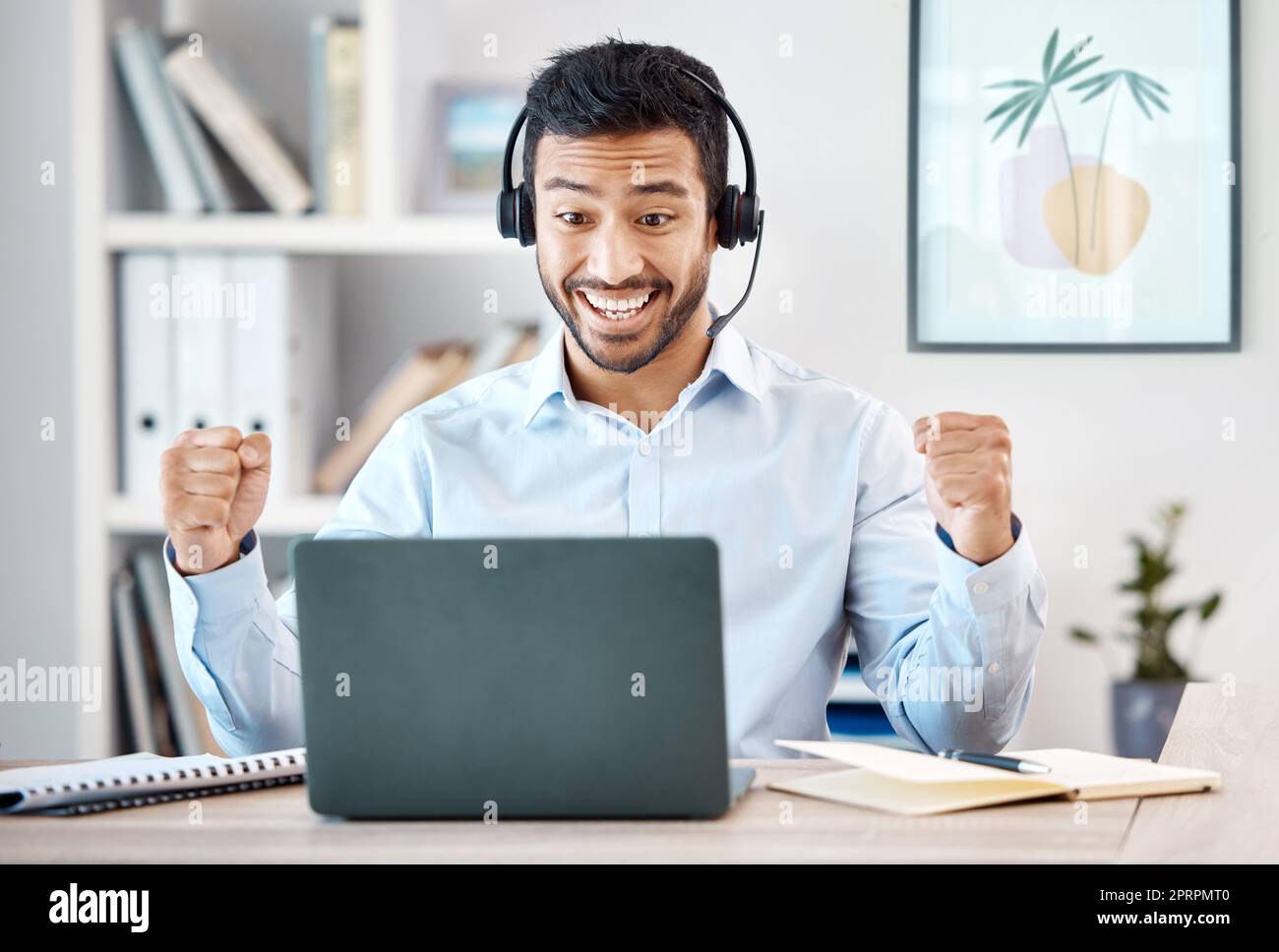 Call center, uomo asiatico e successo trattano il laptop nel servizio clienti, contattateci per l'assistenza clienti o per l'ufficio di consulenza crm. Wow, il vincitore e felice consulente di telemarketing con un sorriso che incoraggia il lavoro b2b Foto Stock