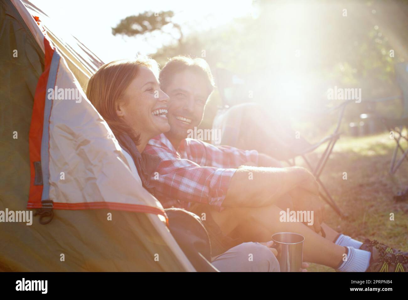 Godersi la natura insieme. Una giovane coppia seduta accanto alla tenda. Foto Stock