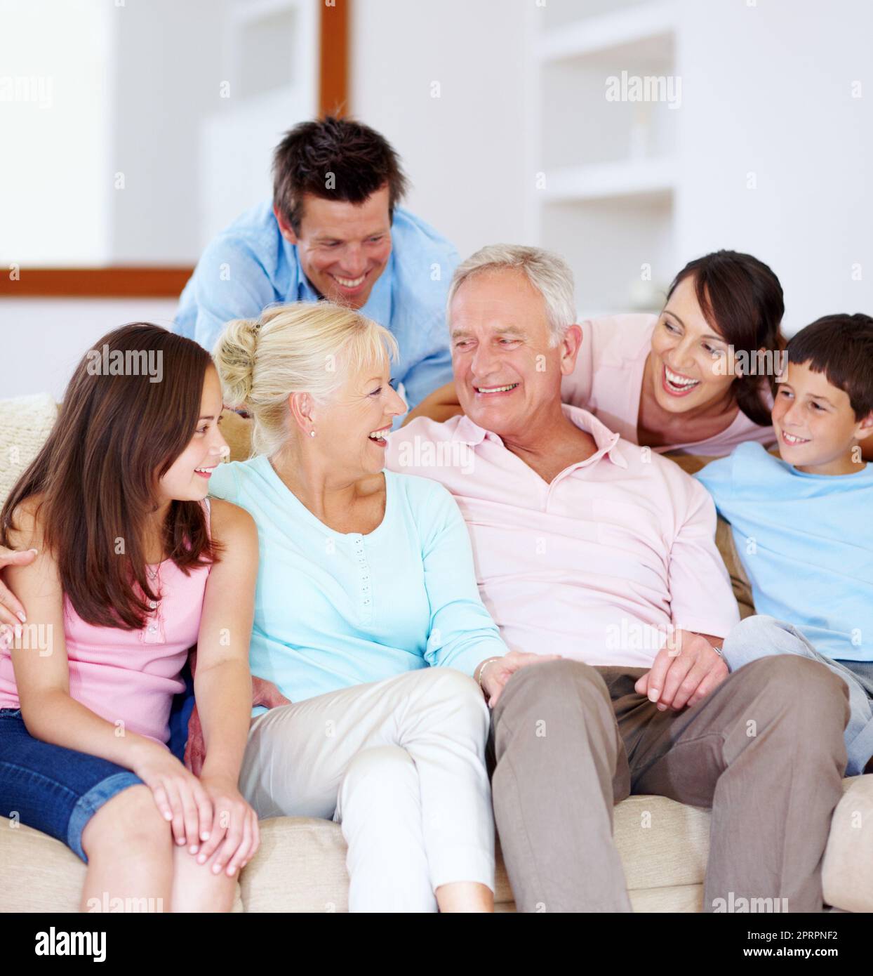 Risate, amore e affetto. Una famiglia che ama ridere insieme su un divano. Foto Stock