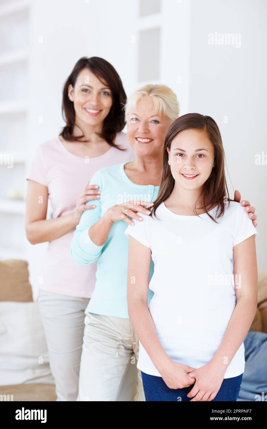 Famiglia attraverso i secoli. Ritratto di una nipote, madre e nonna che si tengono felicemente in una linea di receding. Foto Stock