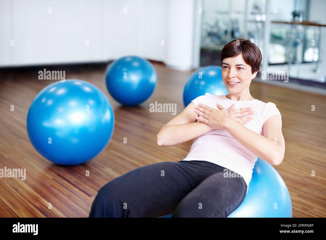Donna che fa sedersi in su sulla sfera di esercitazione. Donna sana che fa addominale siede su palla esercizio. Foto Stock