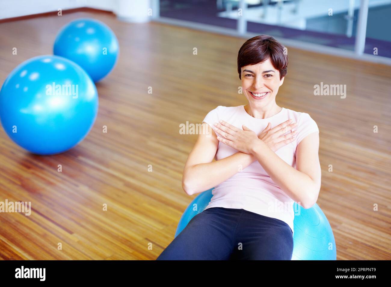 Felice con l'allenamento. Ritratto di donna felice che fa sedere su pilates palla. Foto Stock