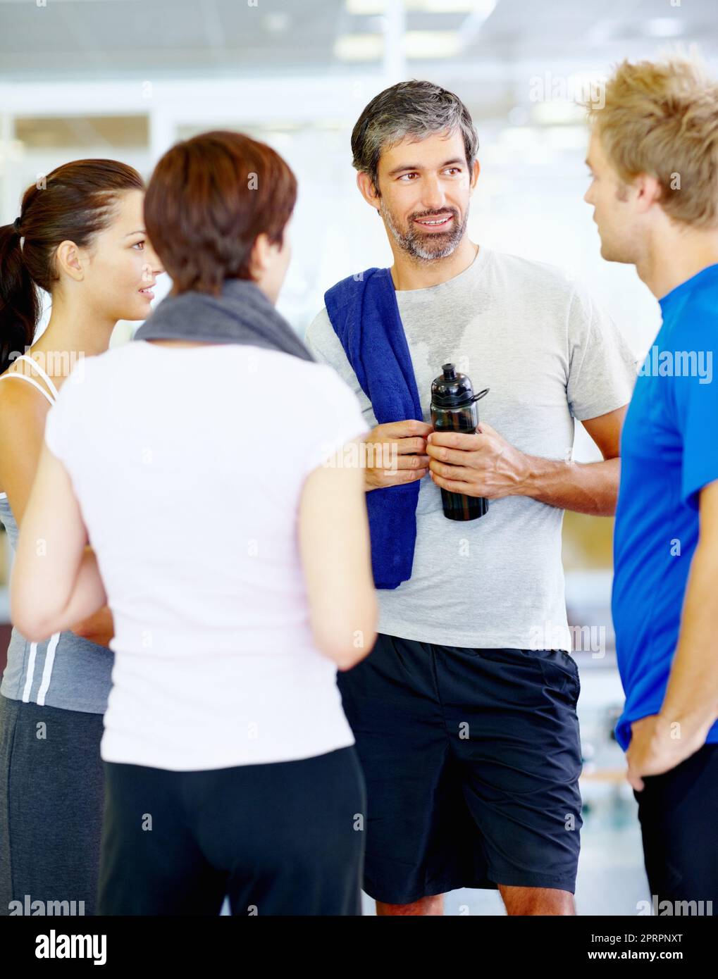 Gli amici si rilassano dopo l'esercizio fisico. Ritratto di uomo maturo che parla con gli amici al centro fitness. Foto Stock