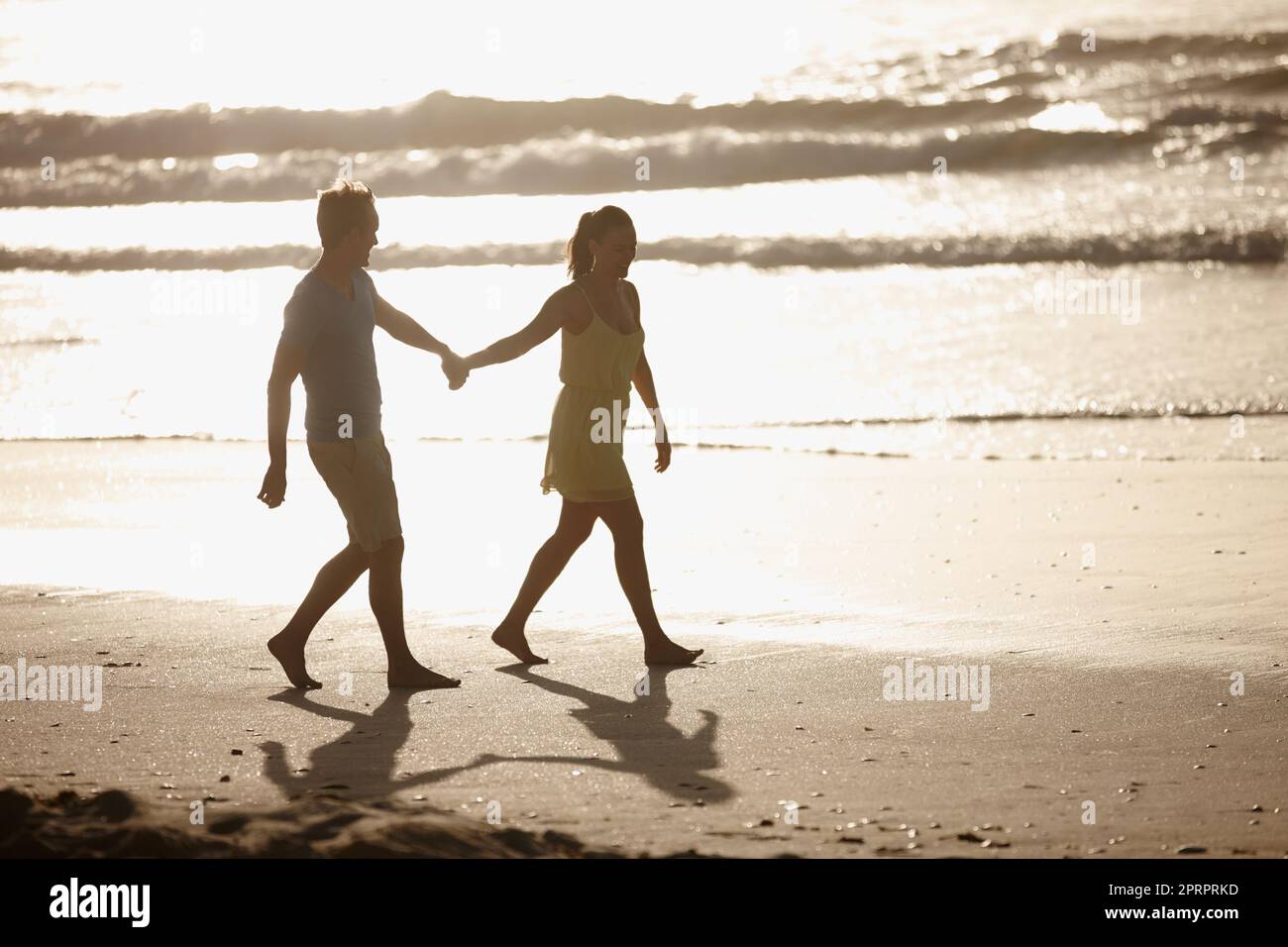Ci sono lunghe passeggiate sulla spiaggia e una coppia affettuosa che cammina sulla spiaggia. Foto Stock