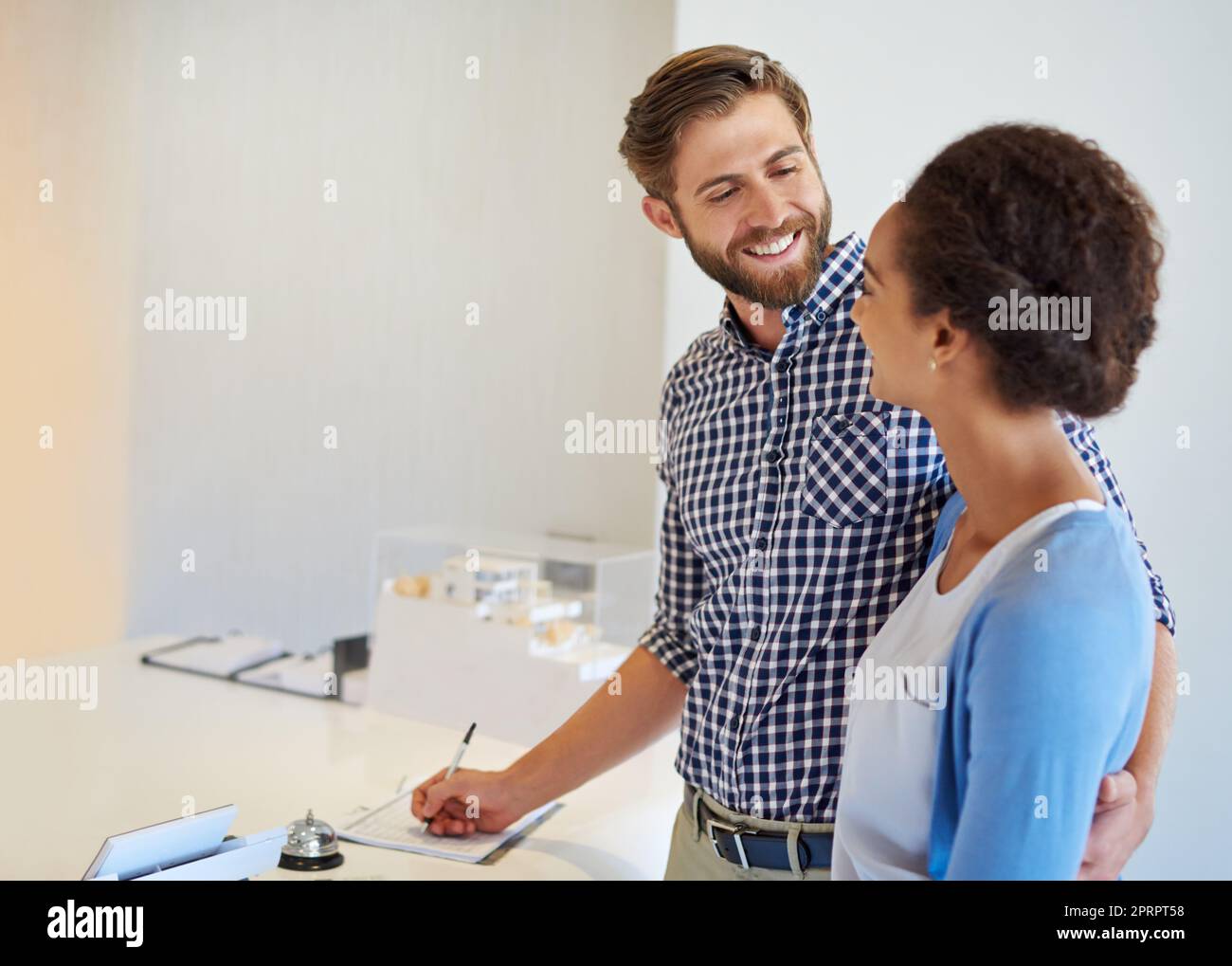 Il soggiorno è stato fantastico: Una giovane coppia in piedi alla reception dell'hotel. Foto Stock