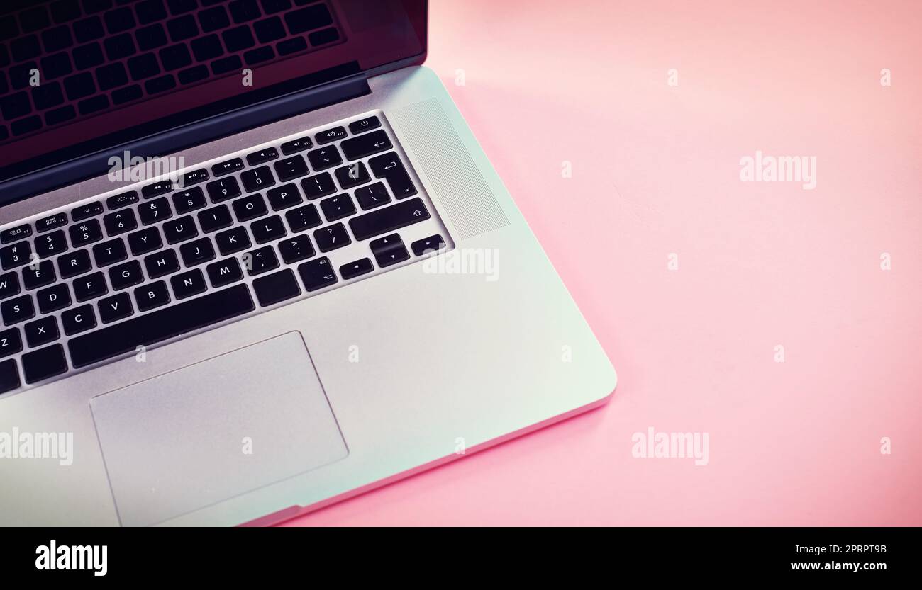 Facile accesso al mondo online. Studio di un notebook su sfondo rosa. Foto Stock