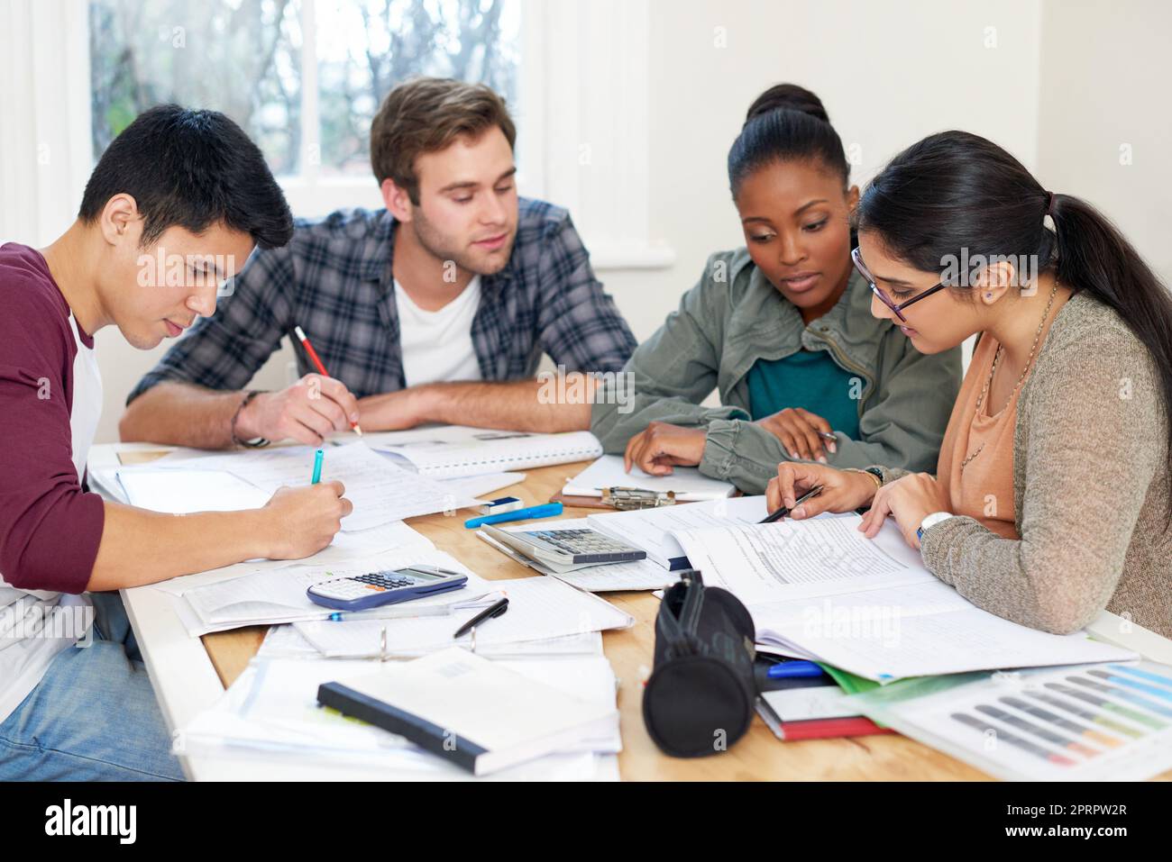 Aiutarsi a vicenda attraverso la revisione delle finali. Un gruppo di studenti universitari in un gruppo di studio. Foto Stock