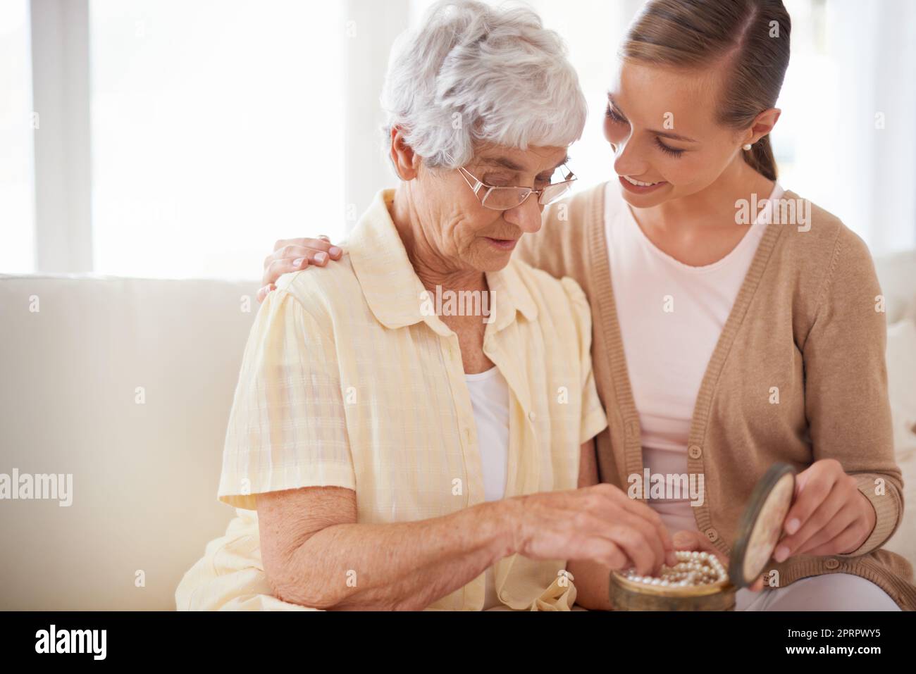 Questo è il loro heirloom di famiglia. Una donna anziana che dà a sua figlia una collana di perle. Foto Stock