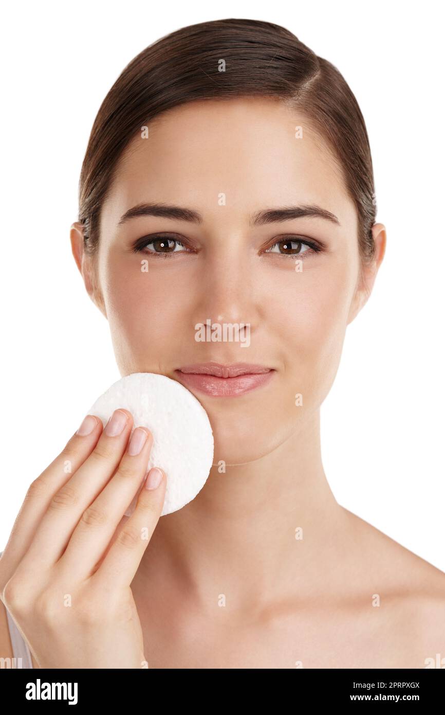 Mantenere la pelle pulita. Ritratto ritagliato di una bella giovane donna che esfolia il volto su uno sfondo bianco. Foto Stock