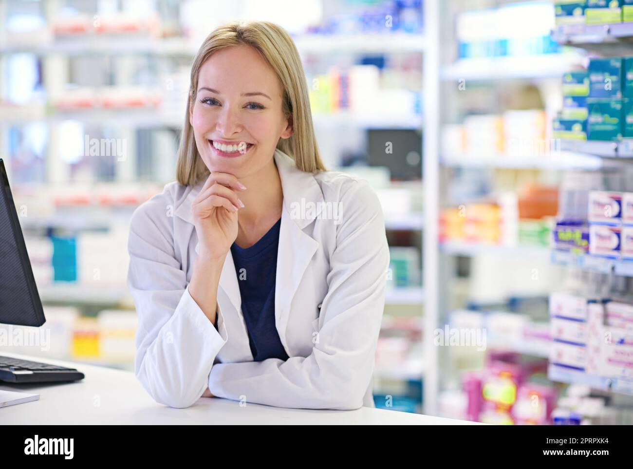 Aiutare i miei clienti a migliorare è la sensazione migliore. Ritratto di un attraente farmacista in piedi al banco di prescrizione. Foto Stock