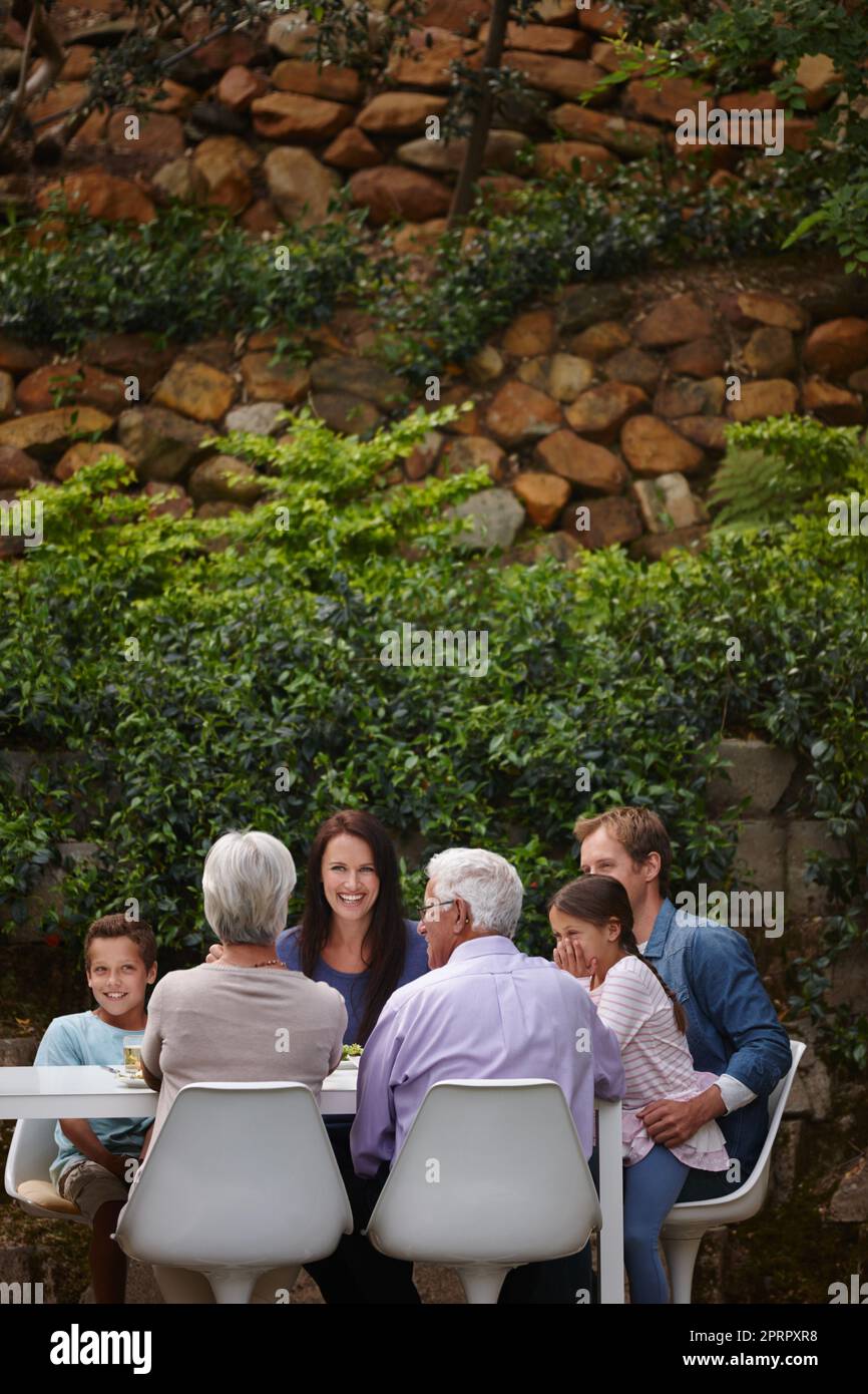 Tempo di qualità. Una famiglia multi-generazionale felice che ha un pasto insieme fuori. Foto Stock