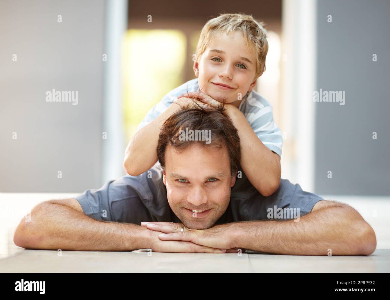Padre come figlio. Ragazzo sopra il papà e poggiato sulla testa. Foto Stock
