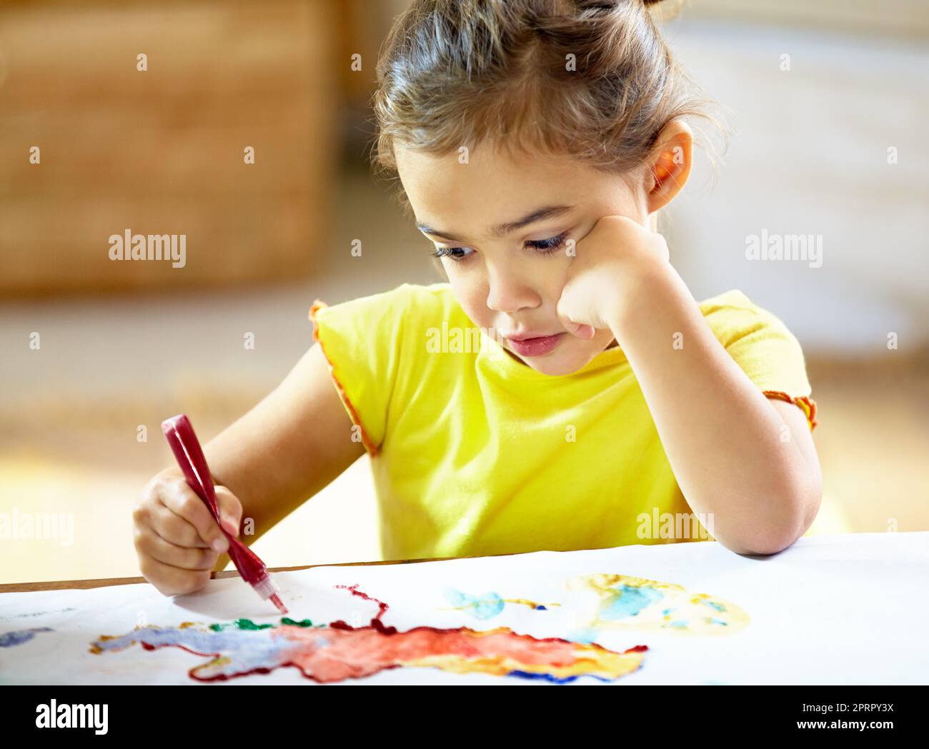Theres nessun limite ad un'immaginazione dei childs. Una ragazza piccola adorabile che fa un mess mentre dipinge. Foto Stock