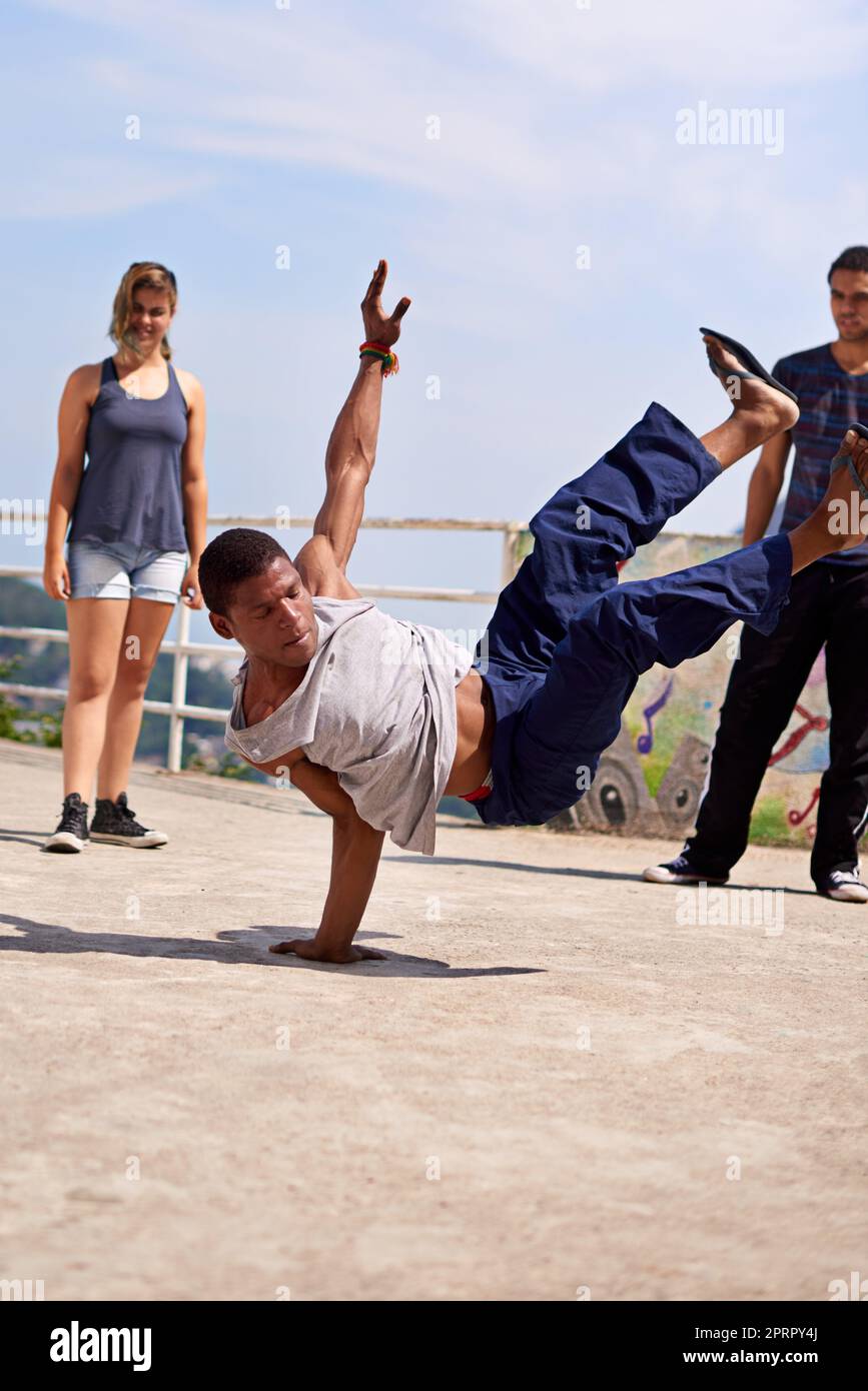 Intrattenimento di strada. Un gruppo di giovani che guardano un breakdancer per le strade. Foto Stock