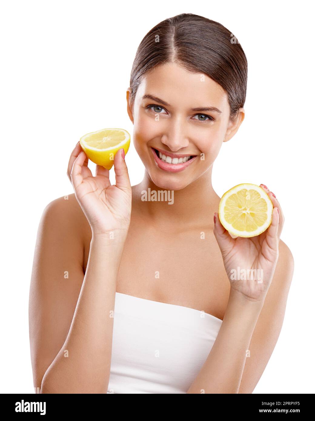 Aggiungi un po' di freschezza alla tua pelle. Studio ritratto di una giovane donna che tiene due metà di un limone. Foto Stock
