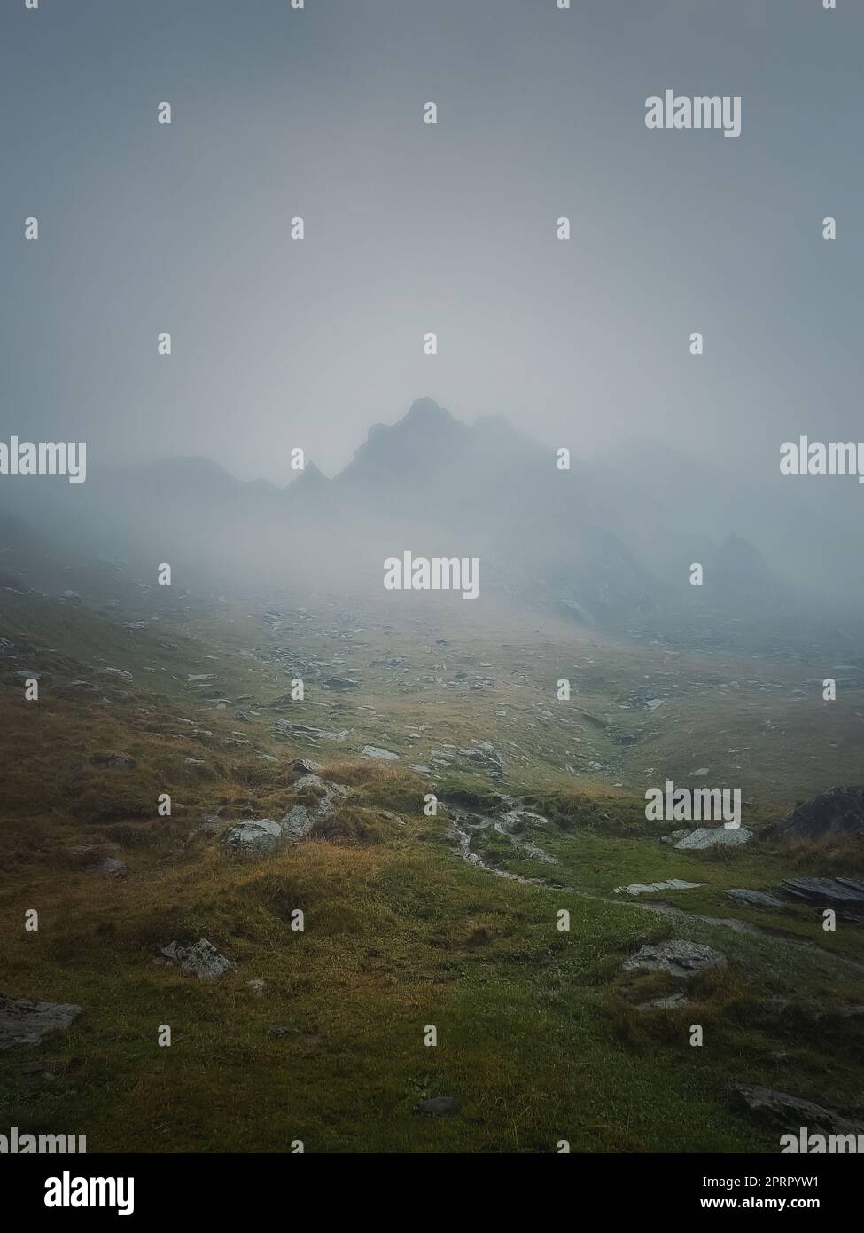 Il picco della Transfagarasan si vede attraverso la fitta nebbia. Scenario piovoso nei monti, escursioni nella nebbia Foto Stock