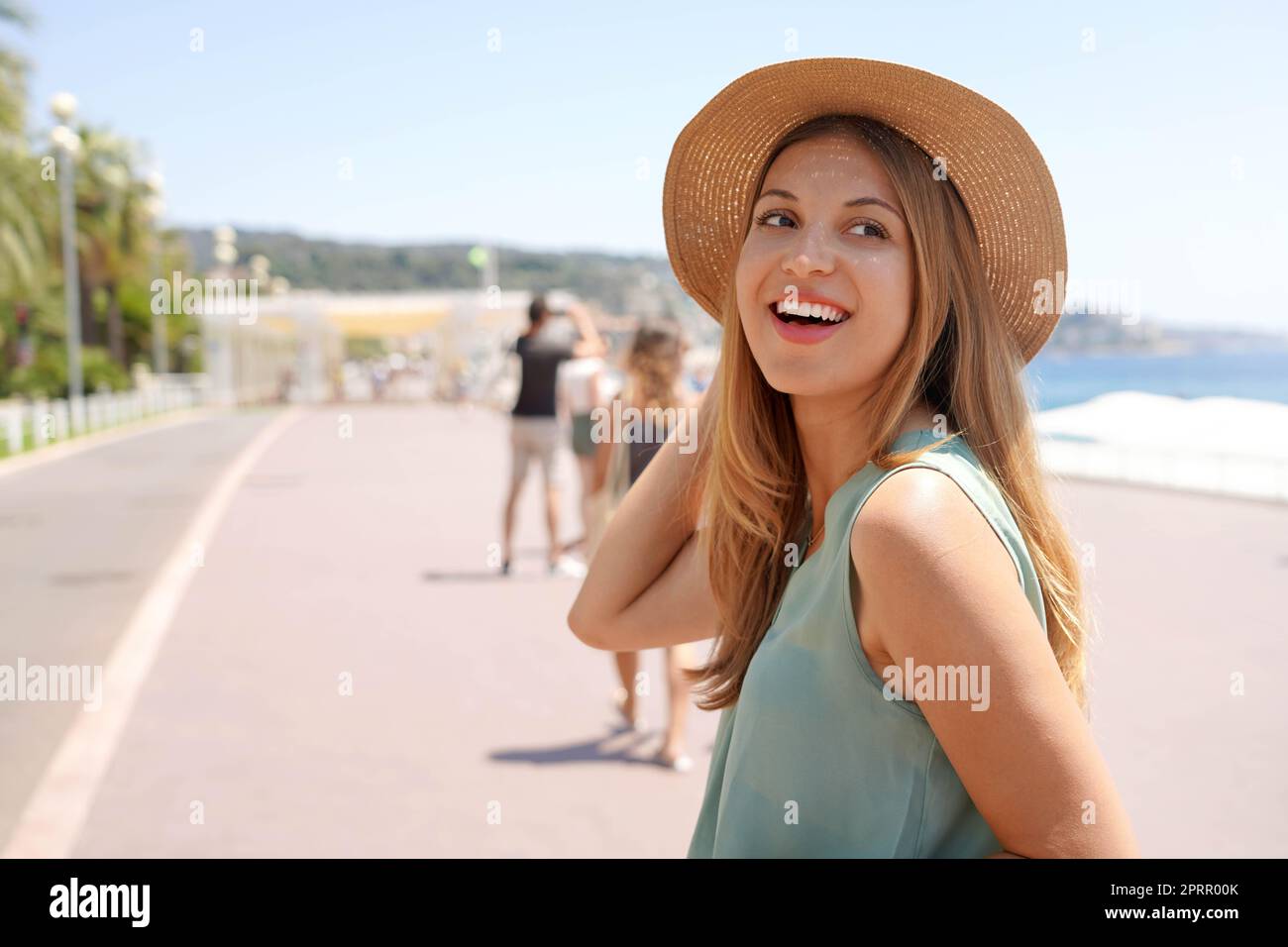 Primo piano di un'elegante ragazza si gira e guarda indietro sulla Promenade des Anglais, Nizza, Francia Foto Stock