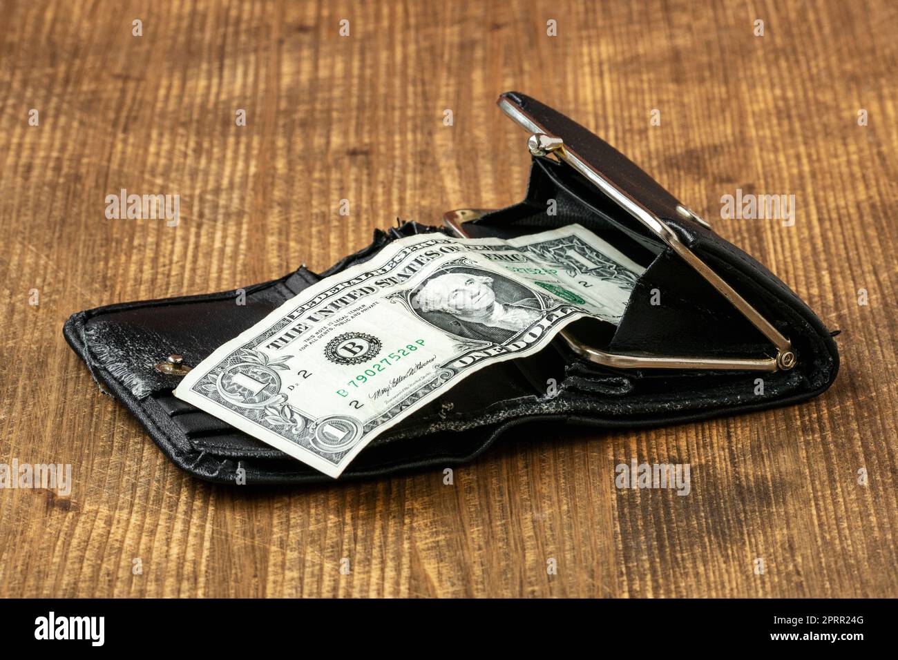 Un dollaro americano in un vecchio portafoglio di pelle su sfondo di legno Foto Stock