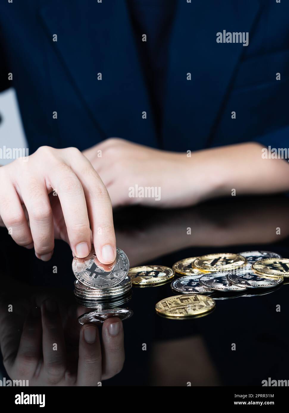 Donna che tiene alcuni pezzi di gettone Bitcoin dorato Foto Stock