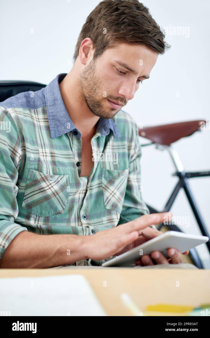 Portare il lavoro ad un altro livello. Un giovane designer seduto alla sua scrivania d'ufficio. Foto Stock