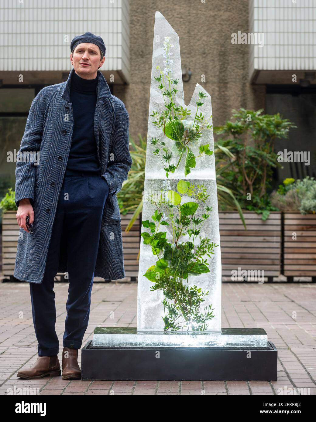 Londra, Regno Unito. 27 aprile 2023. Il compositore e artista concettuale scozzese Erland Cooper accanto a ‘Glacier’, la sua alta scultura di ghiaccio in fusione, nella corte di scultura del Barbican con la quale rimarrà fino a quando non si scioglierà. La sua lenta protesta esamina la natura del cambiamento climatico e anticipa il suo prossimo album “folded Landscapes”, che raccoglierà fondi per la beneficenza EarthPercent di Brian Eno. Credit: Stephen Chung / EMPICS / Alamy Live News Foto Stock